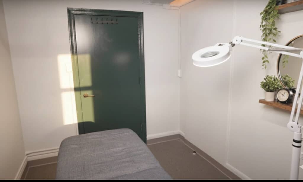 Salon suite rental in NYC with massage bed, wall art, and skincare equipment ready for PMU or facial artist.