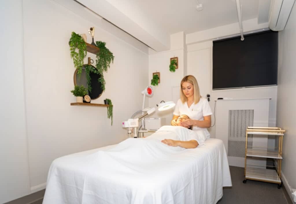 Esthetician performing facial treatment in modern beauty suite for rent in Manhattan.