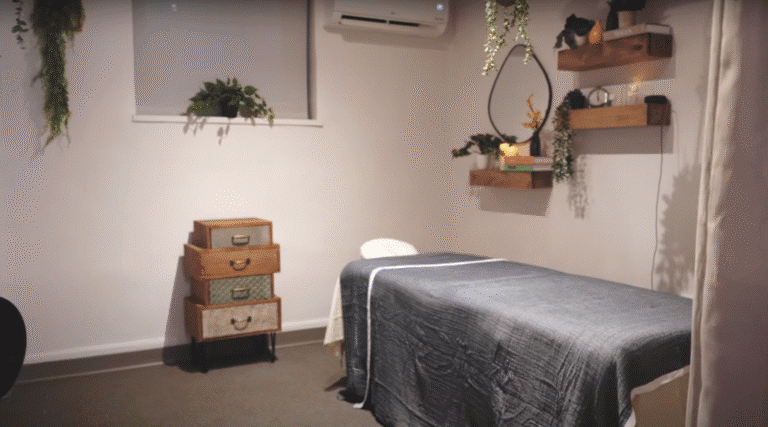 Calm massage treatment room in NYC with plants, candles, and soft lighting for therapists or estheticians. Salon Suite Rental